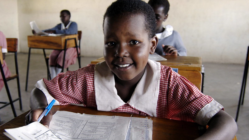 A young Kenyan girl sitting at desk, smiling