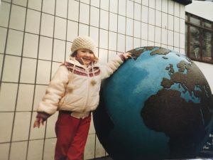 Five-year-old Amanda standing beside a large globe