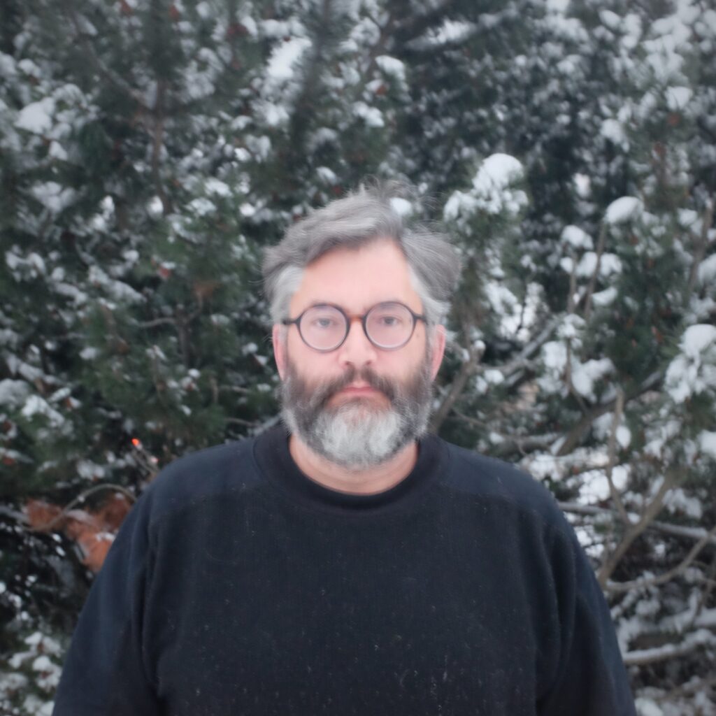 Rob-Roy stands in front of snow-covered trees.