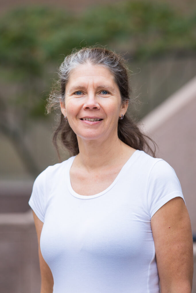 Theresa smiling and standing in an outdoor setting.